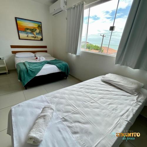 a bedroom with two beds and a window at Encanto da Praia hotel pousada in Natal