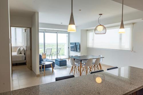 a kitchen and living room with a table and chairs at Ocean Breeze, Cancun Sanctuary - HiveNB in Cancún
