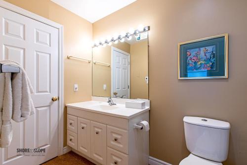 a bathroom with a sink and a toilet and a mirror at Mountain View Villas One Bedroom Suite in Collingwood