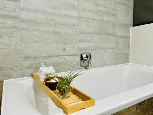 a white bath tub with a tray with a faucet at Bright & Stylish Self Catering Swakopmund CBD in Swakopmund