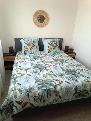 un lit avec une couette colorée et un miroir au mur dans l'établissement Dume et Coco F2 55 M2, à Taglio-Isolaccio