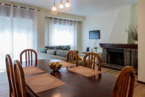 a living room with a dining table and a fireplace at Apartamento Vila Melgaço in Melgaço