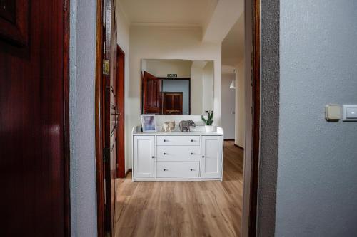 a bathroom with a white sink and a mirror at Apartamento Vila Melgaço in Melgaço