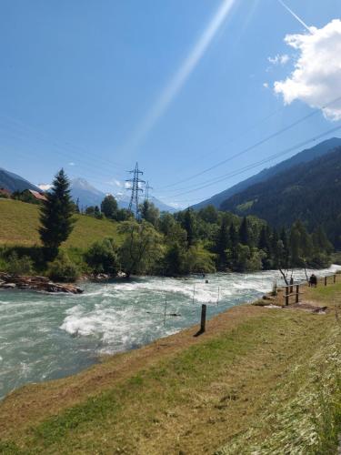 a river with white water and trees on a hill at Am-Christophorus Mölltaler Gletscher in Flattach