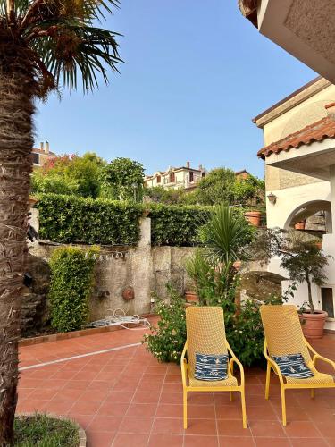two yellow chairs sitting on a patio in a yard at Case Vacanze Torre Petrosa in Villammare