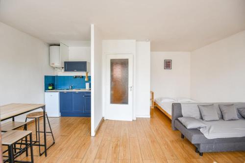 un salon avec un canapé et une table et une cuisine dans l'établissement Bail mobilité - Studio avec balcon proche Timone, à Marseille