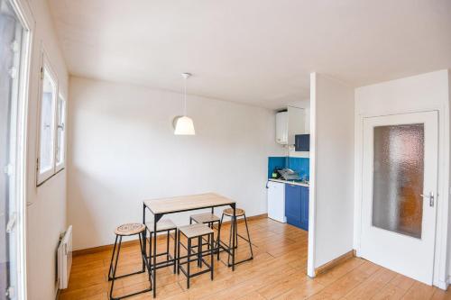 - une cuisine et une salle à manger avec une table et des tabourets dans l'établissement Bail mobilité - Studio avec balcon proche Timone, à Marseille