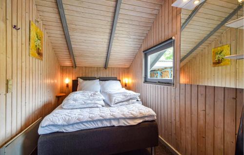 a bed in a small room with wooden walls at Holiday Home Silkeborg With A Fireplace 05 in Funder Kirkeby