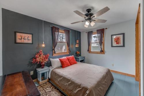 Un dormitorio con una cama y un ventilador de techo. en Wildflower Cottage - Cute Home with Yard & Bonfire, en Pepin