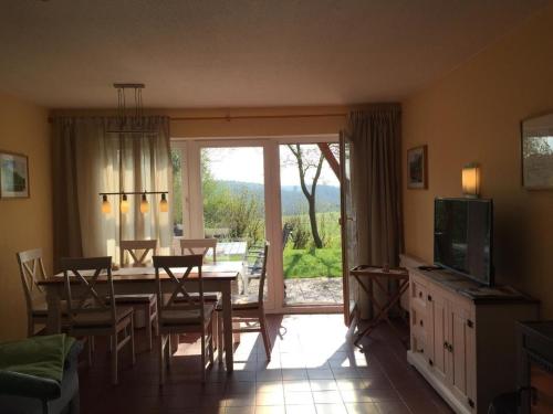 a dining room with a table and chairs and a television at Ferienhaus in Zandt mit Garten, Terrasse und Grill in Zandt
