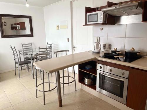 a kitchen with a counter and a table with chairs at HERMOSO DEPTO COND MARINA SOL Lado CASINO ENJOY in Coquimbo