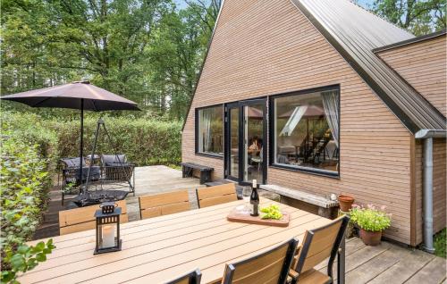 a wooden deck with a table and an umbrella at Cozy Home In Bjerringbro With Wifi in Bjerringbro