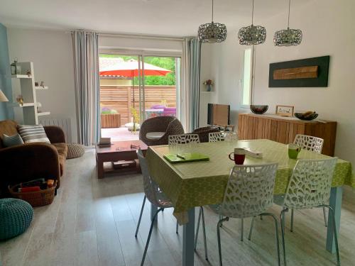 - un salon avec une table à manger et des chaises dans l'établissement Maison au calme dans le golf de Lacanau, à Lacanau