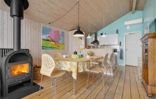 a dining room with a table and a fireplace at Amazing Home In Broager With Kitchen in Broager