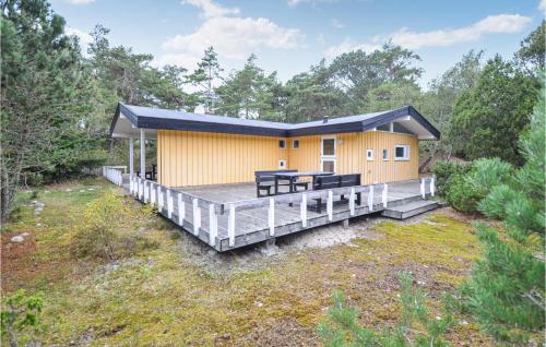 a yellow house with a porch and a deck at Amazing Home In Anholt With Kitchen in Anholt