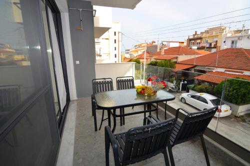 a table and chairs on a balcony with a view at Mavili Luxury Apartments in Kavala