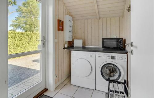 a laundry room with a washing machine and a microwave at 3 Bedroom Cozy Home In Børkop in Børkop
