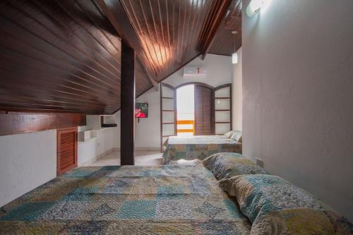 ペルイベにあるRecanto Douradoのベッドが2つあり、天井が木製の寝室