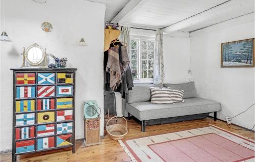 a living room with a chair and a book shelf at Amazing Home In Rønne With Kitchen in Rønne