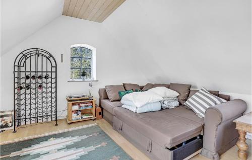 a living room with a couch with pillows on it at Amazing Home In Rønne With Kitchen in Rønne