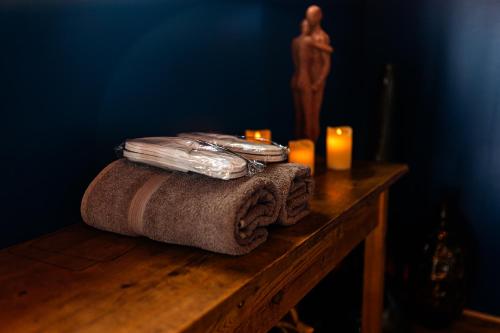 - une table en bois avec des serviettes et des bougies dans l'établissement OZ LOVE ROOM JACUZZI privatif, à La Croix-Saint-Leufroy