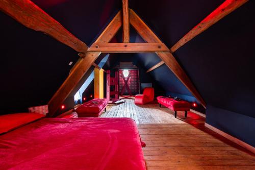 une chambre mansardée avec des lits rouges et des murs bleus dans l'établissement OZ LOVE ROOM JACUZZI privatif, à La Croix-Saint-Leufroy