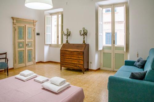 a living room with a blue couch and a table at Honoré de Balzac in Alghero
