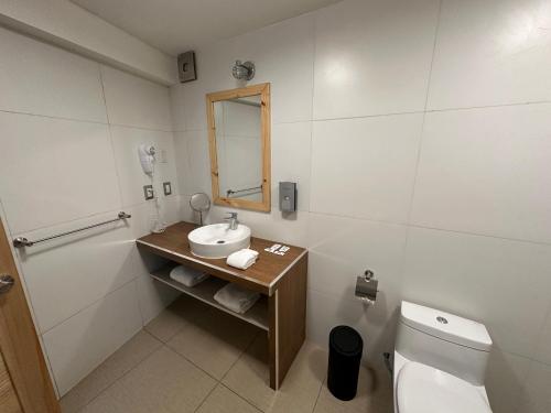 a bathroom with a sink and a toilet and a mirror at CASA CRISTOBAL Centenario in Cusco