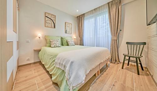une chambre avec un lit, une chaise et une fenêtre dans l'établissement L'Escale-Appartement Saint-Tropez-4 personnes- Piscine-garage, à Saint-Tropez