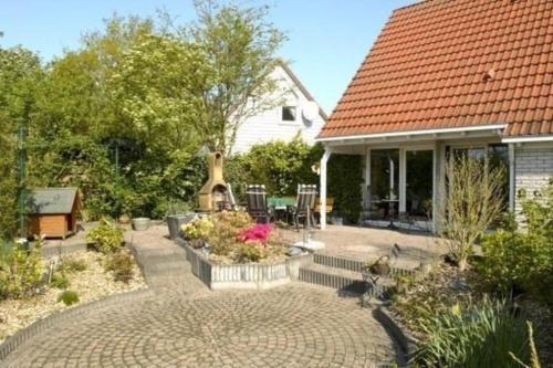 a home with a patio with a table and chairs at Ferienhaus Cosima mit schönem Garten in Anjum