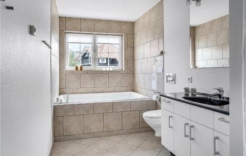 a bathroom with a tub and a toilet and a sink at 3 Bedroom Nice Apartment In Bogense in Bogense