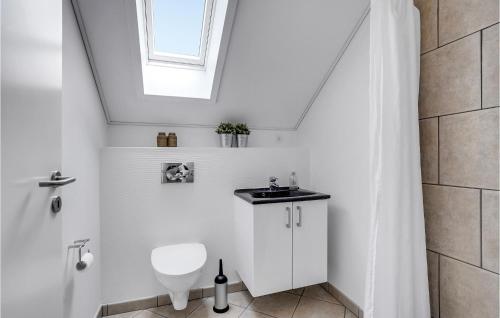a white bathroom with a toilet and a window at 3 Bedroom Nice Apartment In Bogense in Bogense