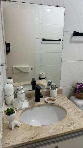 a bathroom with a sink and a toilet and a mirror at Flat Summer House Genipabu AGORA TÉRREO in Guarajuba