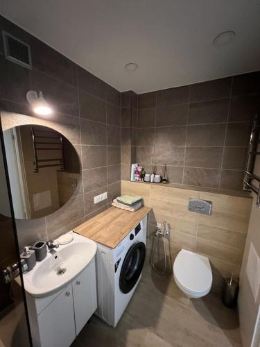 a bathroom with a washing machine and a sink at Like at home Daumani in Narva