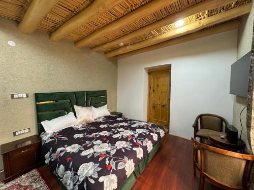 a bedroom with a bed and a desk and a television at Taj Guest House, Leh in Leh