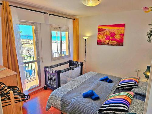 a bedroom with a bed with two blue slippers on it at Beachfront Duplex 1ª línea & Terraces Oceanfront in El Puerto de Santa María