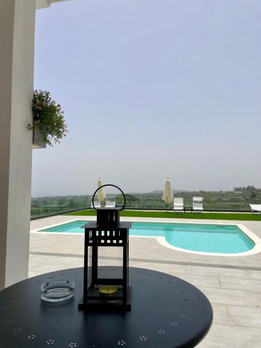 a table with a candle on top of it next to a pool at Maison Divaga in Fleri
