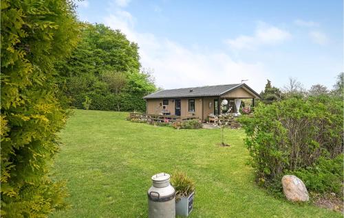 a house in a yard with a fire hydrant in the grass at Beautiful Home In Haarby With Kitchen in Brunshuse