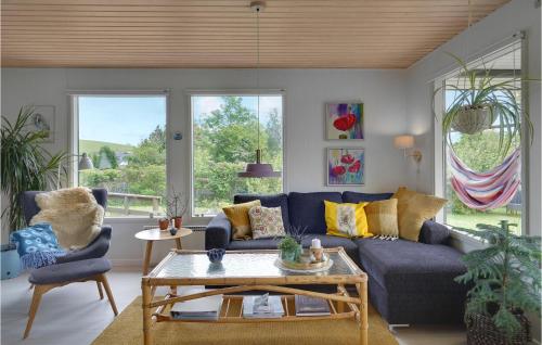 a living room with a blue couch and two chairs at Beautiful Home In Haarby With Kitchen in Brunshuse