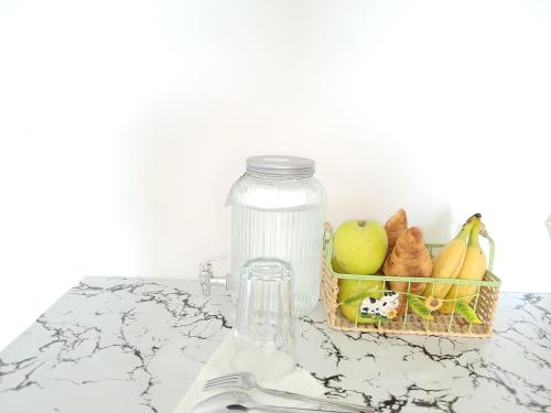un bocal en verre et une corbeille de fruits sur un comptoir dans l'établissement 5 Star Beautiful Premuim Appartment, Évry-Courcouronnes