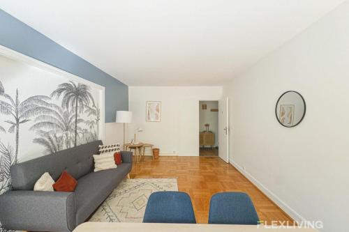 - un salon avec un canapé gris et des fauteuils bleus dans l'établissement Flexliving - room - Saens, à Paris