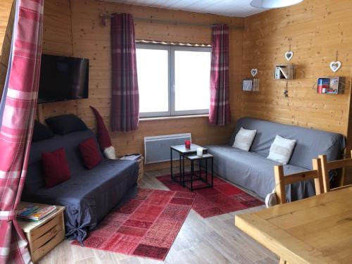 Una sala de estar con dos sofás y un televisor. en Appartement Chalet, 8 personnes - L'Oustal, en Saint-Jacques-des-Blats