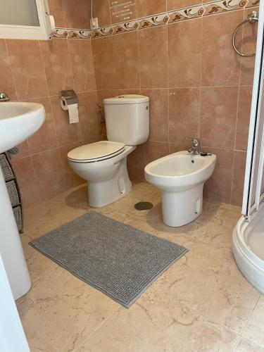 a bathroom with a toilet and a bidet and a sink at casita las Perlas in Cómpeta