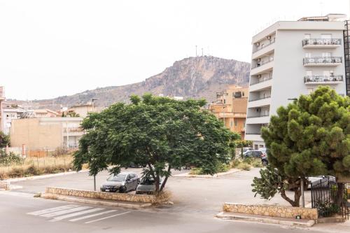 a parking lot with two trees and a building at Bagheria Home in Bagheria