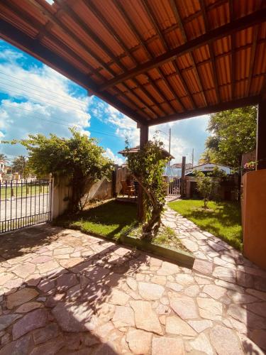 a patio with a wooden pergola in a yard at Pontal dos Sonhos- Chalés Praia do Farol in Coruripe