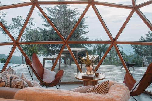 a room with a large window with chairs and a table at Terramia Estate in Minca