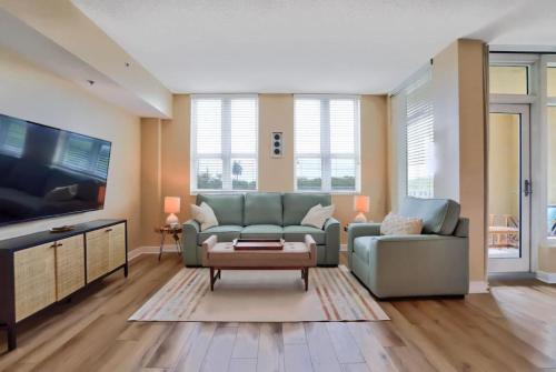 a living room with a couch and a tv at Studio with rooftop pool in Boynton Beach in Boynton Beach