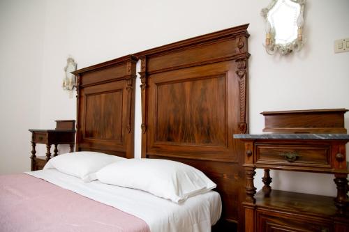 a bed with a wooden headboard next to a table at Honoré de Balzac in Alghero