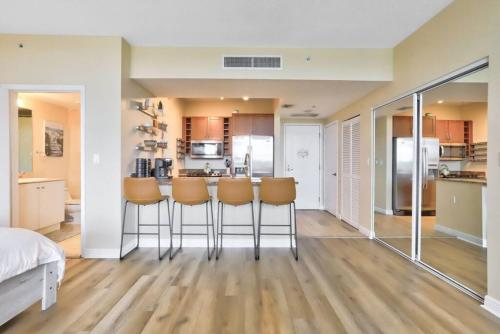 a living room with a kitchen with stools in it at Studio with rooftop pool in Boynton Beach in Boynton Beach