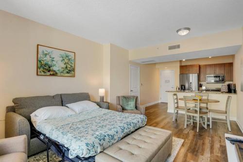 a bedroom with a couch and a table in a room at 1 BR King- Rooftop Pool close to beach Casa Costa in Boynton Beach